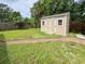 Backyard featuring a neutral shed with double doors and a well-maintained grassy area with brick pavers at 774 Hendrix Ave, Orlando, FL 32825