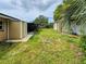 Large backyard featuring a shed, green grass, and a screened in porch at 774 Hendrix Ave, Orlando, FL 32825