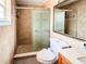 Bathroom features a shower with glass doors, tiled walls, and a white toilet at 774 Hendrix Ave, Orlando, FL 32825
