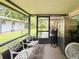 Cozy screened porch with white iron chairs, fan, and stainless refrigerator, perfect for relaxing outdoors at 774 Hendrix Ave, Orlando, FL 32825
