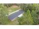 Aerial view of the home showing the roof and expansive backyard space with trees and a patio at 3207 Cr 419, Lake Panasoffkee, FL 33538