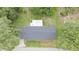 Overhead view of a home featuring a dark grey roof with lush surrounding trees at 3207 Cr 419, Lake Panasoffkee, FL 33538