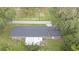 Aerial view showcases the home's roof, backyard, mature trees, patio, and proximity to the road at 3207 Cr 419, Lake Panasoffkee, FL 33538