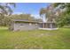 Home featuring a screened in patio, a spacious yard, and a serene backyard setting at 3207 Cr 419, Lake Panasoffkee, FL 33538