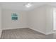 Clean bedroom featuring gray laminate flooring, a modern ceiling fan, and a bright window at 3207 Cr 419, Lake Panasoffkee, FL 33538