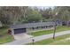 Ranch-style home featuring an attached garage, new roof, and manicured front lawn at 3207 Cr 419, Lake Panasoffkee, FL 33538