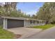 Charming single-story home with a dark grey attached garage, complemented by well-maintained landscaping at 3207 Cr 419, Lake Panasoffkee, FL 33538