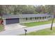 Charming home with a gray facade, black shutters, manicured lawn, attached garage, and inviting curb appeal at 3207 Cr 419, Lake Panasoffkee, FL 33538