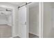 Hallway with gray laminate flooring showing a walk-in closet with sliding barn door at 3207 Cr 419, Lake Panasoffkee, FL 33538