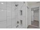 Elegant shower with white marble tiles and recessed shelving niche, open to a walk-in closet at 3207 Cr 419, Lake Panasoffkee, FL 33538