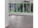 Bright sunroom with tiled floors and numerous windows overlooking lush landscaping at 3207 Cr 419, Lake Panasoffkee, FL 33538