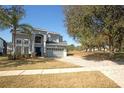 Two-story home with two-car garage on a well-manicured lawn and a paver driveway at 33953 Terragona Dr, Sorrento, FL 32776