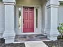 Red front door with sidelights and a slate tile entryway at 518 Marion Oaks Trl, Ocala, FL 34473