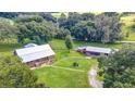A beautiful aerial view of the log home and property, including the expansive green lawn, mature trees, and additional structures at 4292 Sw 73Rd Trl, Bushnell, FL 33513