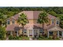Inviting townhome featuring a well-maintained facade with palm trees and a lush green lawn at 17531 Placidity Ave, Clermont, FL 34714
