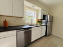 Modern kitchen with stainless steel appliances, bright white cabinets, and sleek black countertops at 766 Bates Sw Ave, Winter Haven, FL 33880