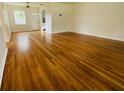 Spacious living room featuring gleaming hardwood floors and ample natural light from the front windows at 766 Bates Sw Ave, Winter Haven, FL 33880