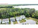 A stunning aerial view showcases a perfectly situated home on a large lot with a nearby lake and wooded surroundings at 29912 Cypress Pointe, Deer Island, FL 32778