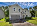Inviting two-story home with a stone-accented entrance and a brick driveway, offering both charm and sophistication at 29912 Cypress Pointe, Deer Island, FL 32778