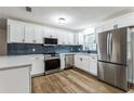 Modern kitchen with white cabinets, stainless steel appliances, and blue tile backsplash at 1228 Se 17Th St, Ocala, FL 34471