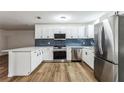 Modern kitchen with white cabinets, stainless steel appliances, and blue tile backsplash at 1228 Se 17Th St, Ocala, FL 34471