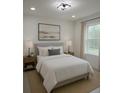 Cozy bedroom with neutral tones, a large window, and stylish furnishings, creating a relaxing retreat at 3245 Se 142Nd Pl, Summerfield, FL 34491