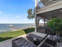 Enjoy waterfront views from this screened-in patio area with lounge chairs at 12943 Se Sunset Harbor Rd, Weirsdale, FL 32195