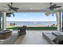 Relaxing covered patio overlooking the lake with fire pit and comfortable seating at 12943 Se Sunset Harbor Rd, Weirsdale, FL 32195