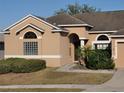 Tan house with arched entryway and well-maintained landscaping at 510 Coventry Rd, Davenport, FL 33897