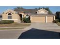 Tan house with three-car garage and manicured lawn at 510 Coventry Rd, Davenport, FL 33897