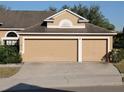 Two-car garage with tan doors and white trim at 510 Coventry Rd, Davenport, FL 33897