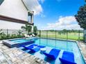 Inviting pool and spa with blue lounge chairs, overlooking a golf course at 1544 Corolla Ct, Reunion, FL 34747