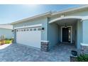 Front entrance with white garage door and stone accents at 7865 Sw 89Th Cir, Ocala, FL 34481