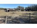 Rustic barn with a metal roof and corral in a large pasture at 2725 Schreffler Rd, Groveland, FL 34736