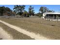 Long dirt driveway leading to a mobile home and fenced yard at 2725 Schreffler Rd, Groveland, FL 34736