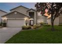 Two-story house with a large lawn and attached garage at 8007 Acadia Estates Ct, Kissimmee, FL 34747