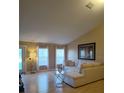 Bright living room with a sectional sofa, large windows, and light wood flooring at 15900 Sw 19Th Avenue Rd, Ocala, FL 34473