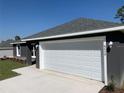 Gray house with white garage door and landscaping at 6459 Sw 204Th Ave, Dunnellon, FL 34431