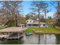 Stunning waterfront home with a private boat dock and lift, lush landscaping, and a sparkling pool at 301 Rippling Ln, Winter Park, FL 32789