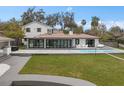 Beautiful backyard with a sparkling pool, outdoor seating, and lush green lawn at 301 Rippling Ln, Winter Park, FL 32789