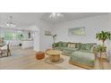 Bright living room with light wood floors and a comfy green sectional sofa at 270 N 1St St, Lake Mary, FL 32746