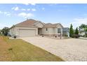 House exterior showcasing a large driveway and well-maintained lawn at 461 Troy Loop, The Villages, FL 32162