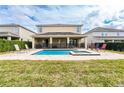 A backyard featuring a swimming pool and spa and patio space with comfortable lounge chairs at 220 Clawson Way, Kissimmee, FL 34747