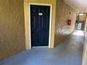 Condo building entrance with dark blue door and light tan walls at 5124 Conroy Rd # 27, Orlando, FL 32811