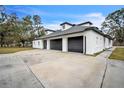 White brick home with a large gray three-car garage at 3045 Dove Ln, Mulberry, FL 33860