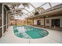 Relaxing kidney-shaped pool with a screened enclosure at 3045 Dove Ln, Mulberry, FL 33860