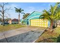 Nice curb appeal with a teal house and yellow garage at 3249 Lake Helen Osteen Rd, Deltona, FL 32738