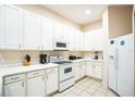 Bright kitchen featuring white cabinetry, appliances, and tile flooring, offering a clean and functional space at 301 New Providence Promenade, Davenport, FL 33897