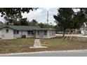 Quaint house with a grey exterior and a swing set in the yard at 11331 Northern Ave, Leesburg, FL 34788