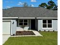 Newly built home showcasing a gray exterior, and a neatly landscaped front yard at 6435 Sw 204 Ave, Dunnellon, FL 34431